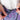 Close-up of hands adjusting the waistband drawstrings of purple and blue patterned shorts.