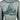 Close up of back of green shirt with a floral pattern, featuring a fish tail design and the pathfinder logo.
