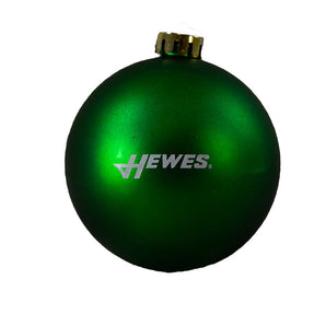 Glossy green Christmas ornament with a gold cap and white hewes logo. 