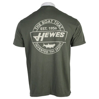 Back view of a green t-shirt featuring a circular logo with the text 'THE BOAT THAT INVENTED THE SPORT' and 'HEWES' along with an established date of 1956.