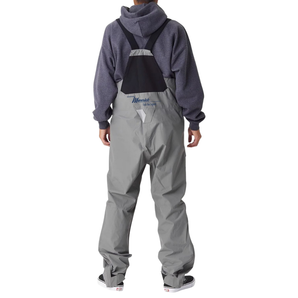 A guy wearing grey fishing bibs from the back, with the maverick logo in blue on the lower back.