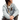 Woman sitting wearing a light grey ribbed quarter zip with the pathfinder logo embroidered in grey on the right sleeve.